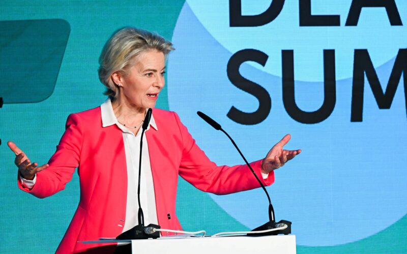 Ursula von der Leyen standing on Green Deal Summit stage with open arms